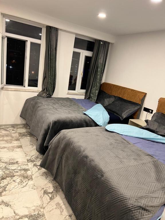 2 camas en un dormitorio con 2 ventanas en Park View 301, en Estambul