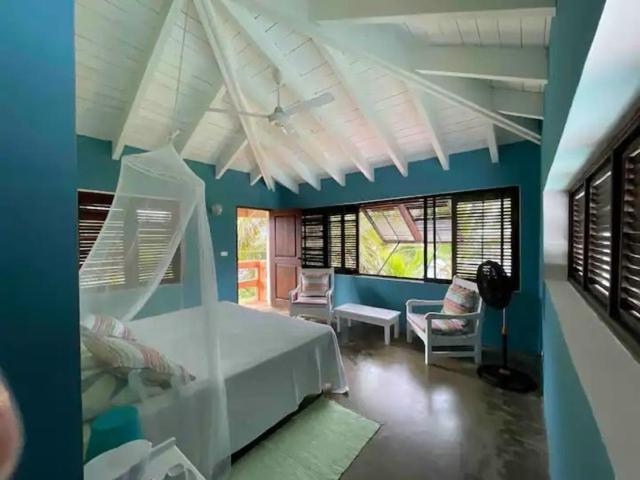 een slaapkamer met een wit bed en een blauwe muur bij Villa Los Gorgones Sea View in Las Galeras