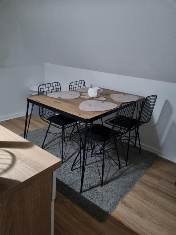 a dining room table with four chairs around it at Weserbergland Apartment in Bodenwerder