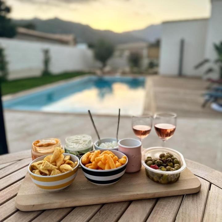 - une table en bois avec des bols de nourriture et des verres de vin dans l'établissement Villa Imagine, à Lecci
