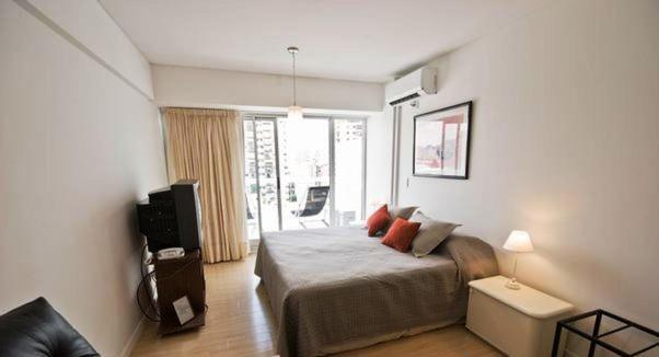 a bedroom with a bed and a television in it at Palermo Soho Apartamento in Buenos Aires