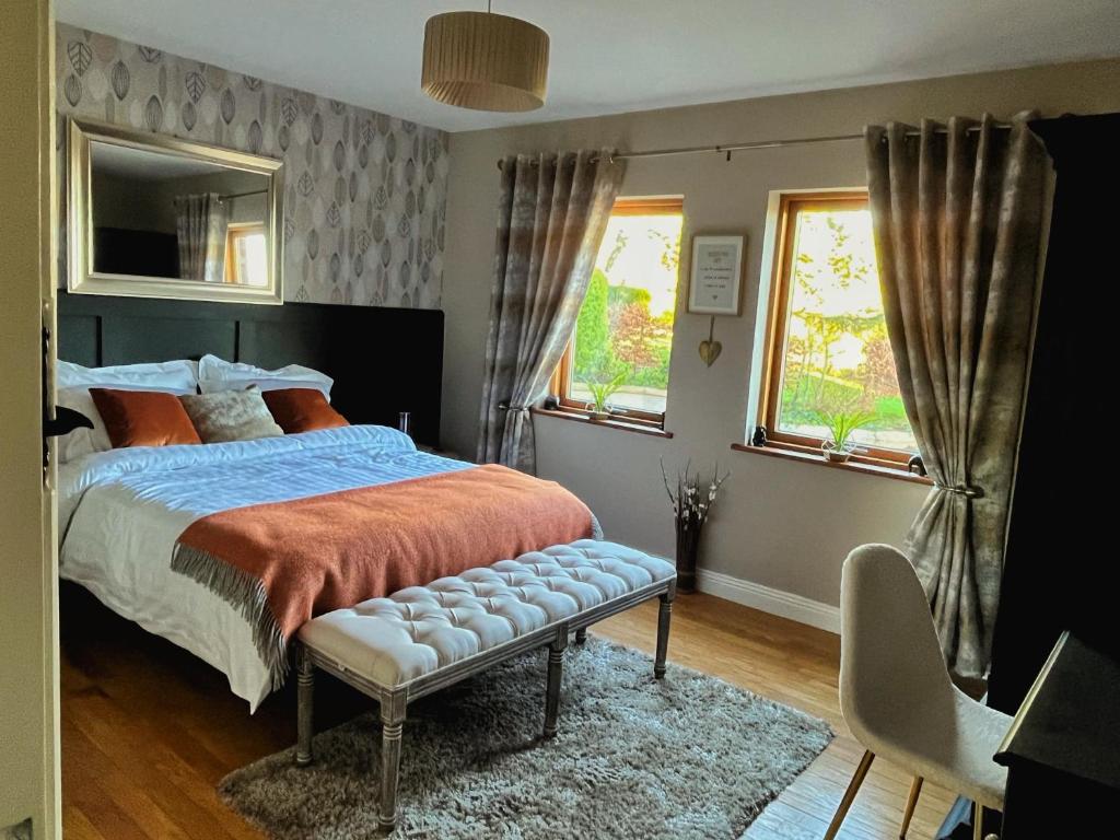 um quarto com uma cama e duas janelas em The Starlings Country House em Wexford