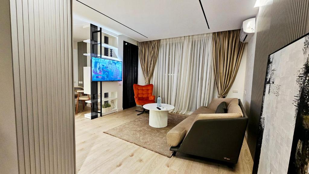 a living room with a couch and a tv at Center Apartment Easy_Luxury in Tirana