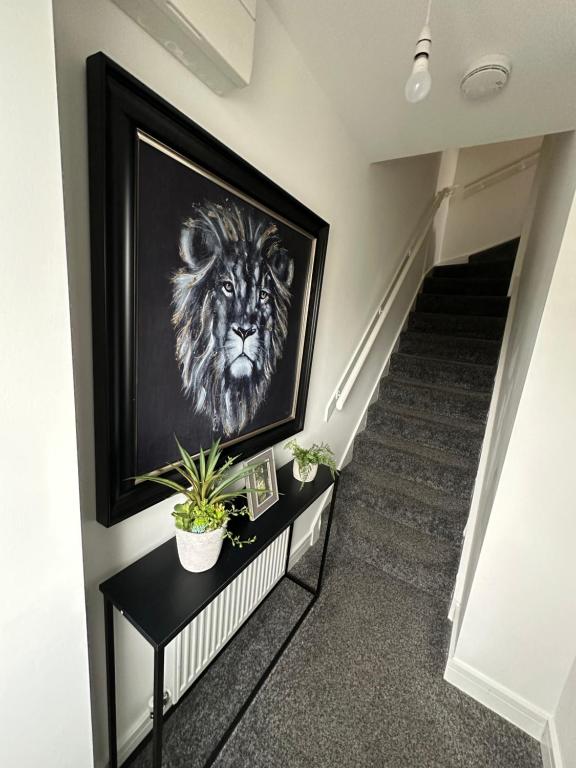 a painting of a lion on a wall next to a staircase at Beautiful home in Ince-in-Makerfield
