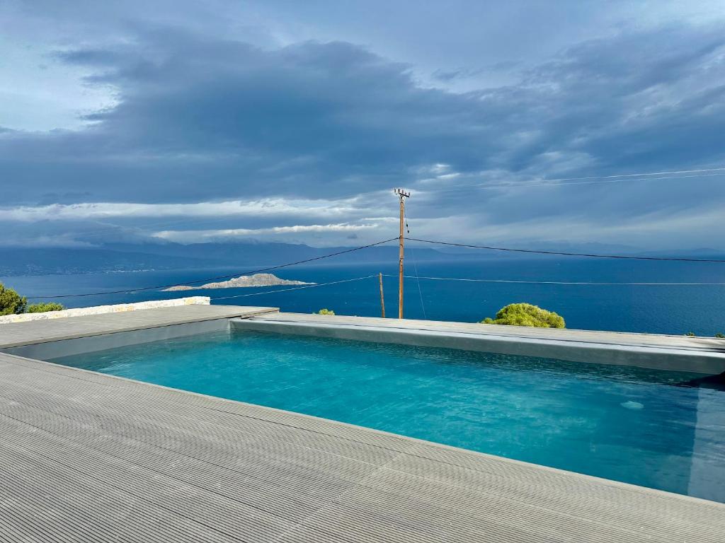 a swimming pool with a view of the ocean at Three Elements in Pefkali