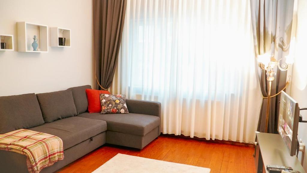 a living room with a couch and a large window at Central Duplex Gem near Taksim & Galata Port in Istanbul