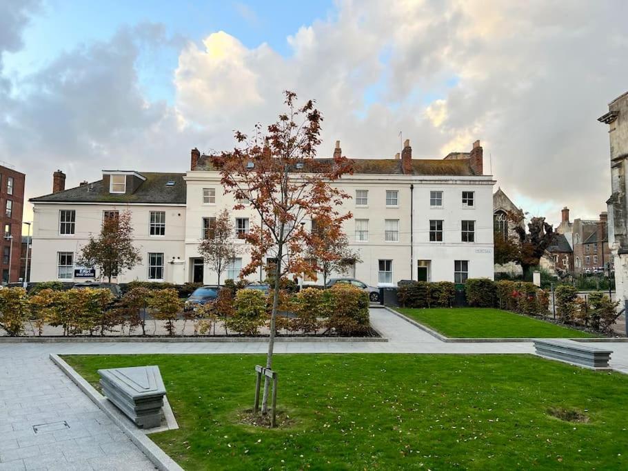 a tree in a park in front of a building at Stylish Ground Floor Apartment Nr Gloucester Docks, by Sauvignon Stays 