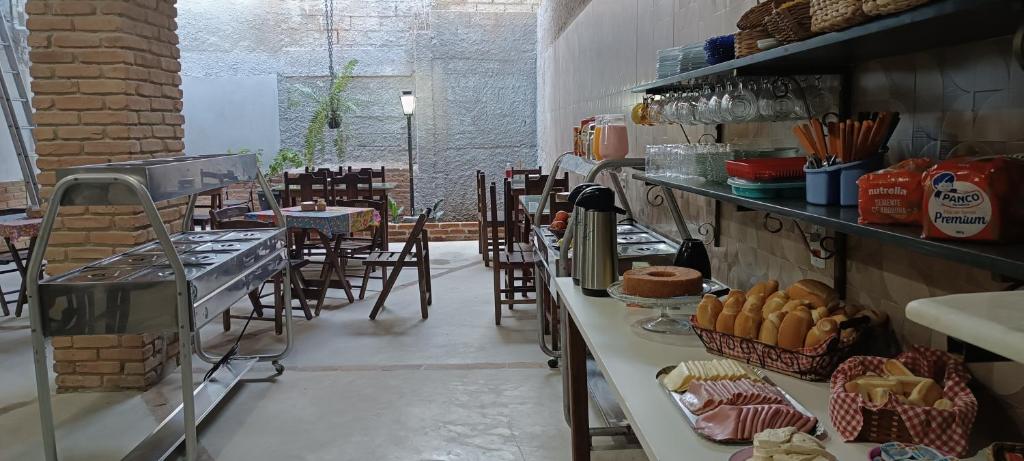 a bakery with tables and chairs and a counter with cakes at Pousada Ribeirinha in Aparecida