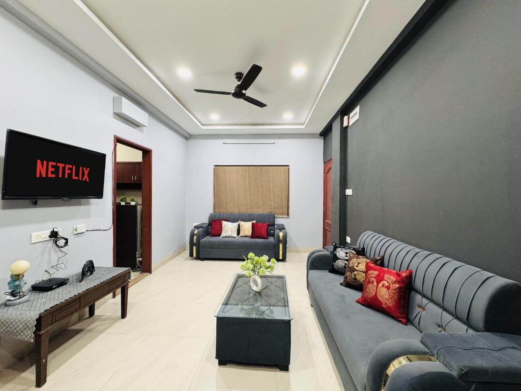 een woonkamer met een bank en een tv bij Home Escape 2BHK Apartment Near Brilliant Convention Centre - Adults Only in Indore