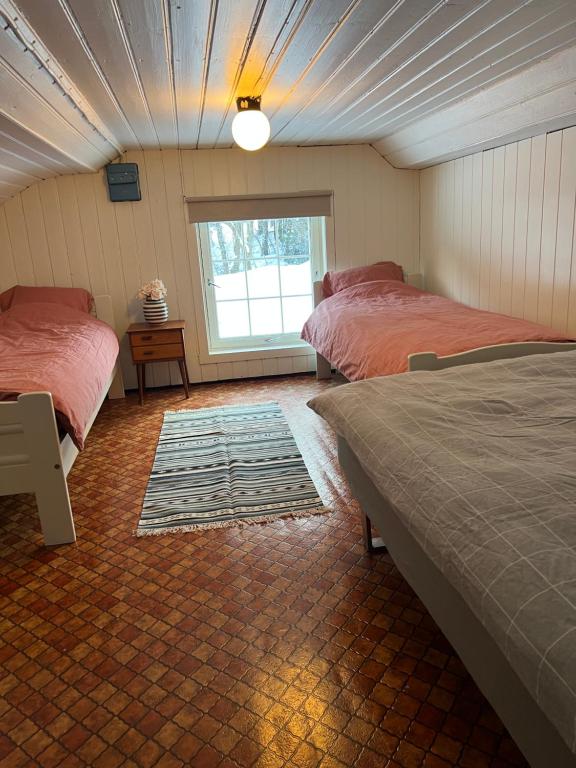 a bedroom with two beds and a window in it at Koselig feriehus sentralt i Sirdal in Tjørhom