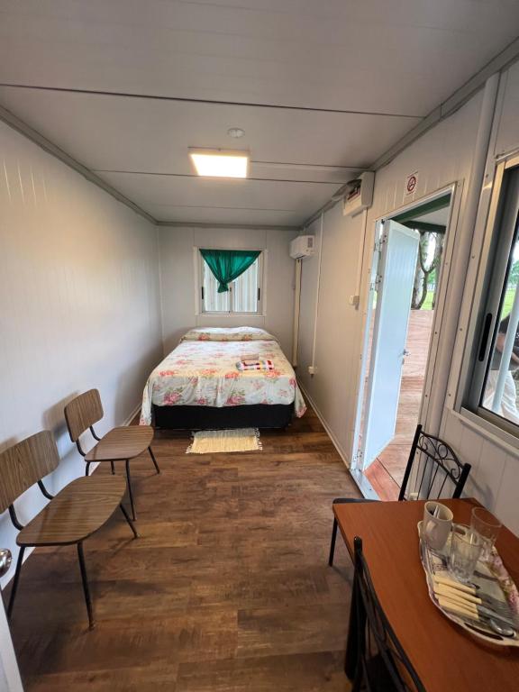 Cette chambre comprend un lit, une table et des chaises. dans l'établissement Cabañas El Calabres, à Tacuarembó