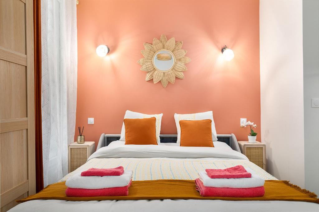 a bedroom with a bed with two pillows on it at Guestrust- Arc de Triomphe Corail in Paris