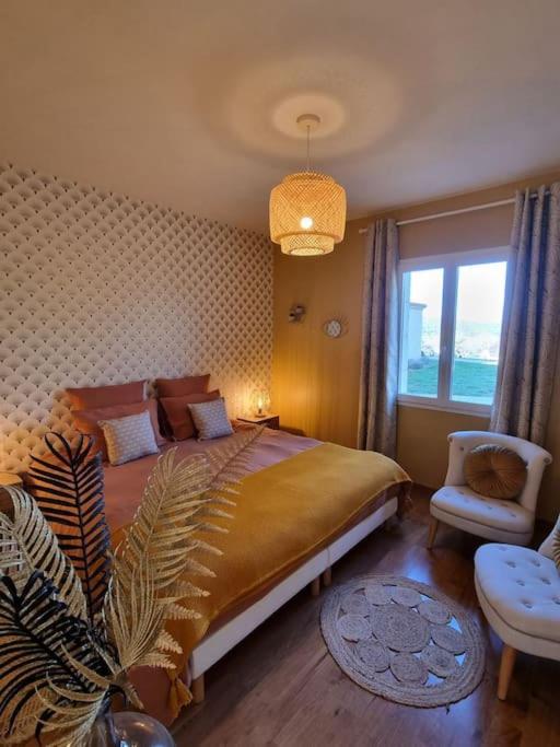 une chambre avec un lit, une chaise et une fenêtre dans l'établissement Gîte de Charme pour 2 pers. dans le Périgord Noir, à Veyrines-de-Domme