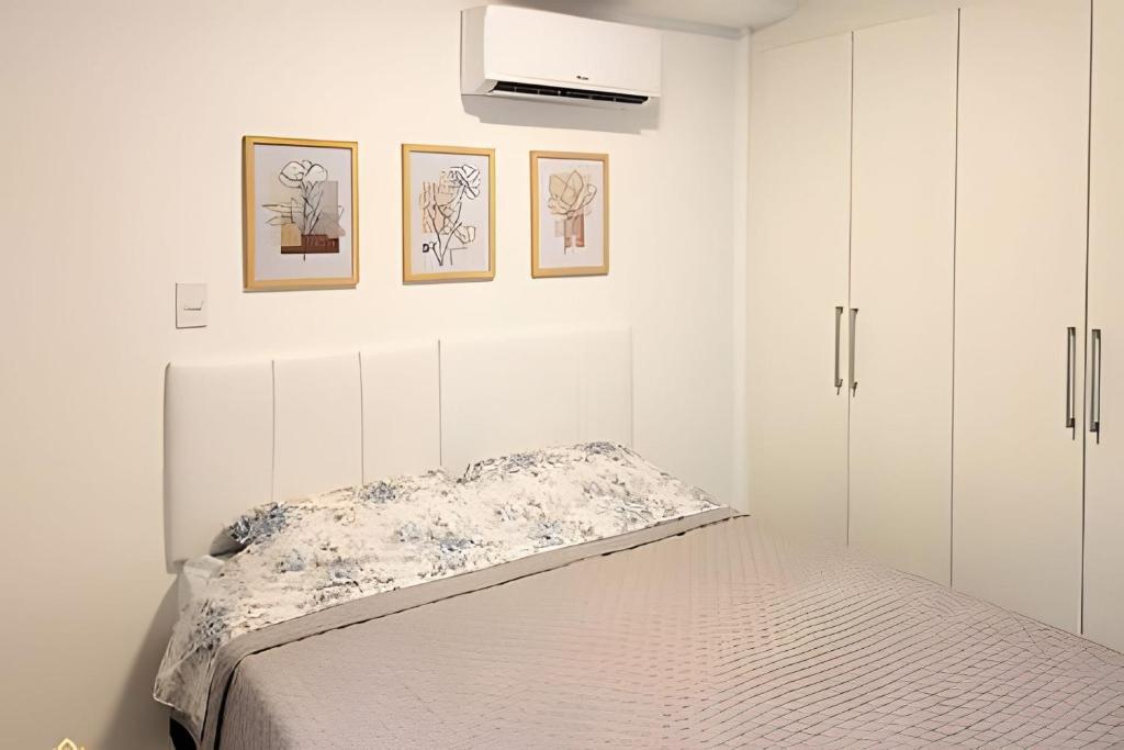 um quarto branco com uma cama e 2 armários em Nosso Apê 915: Ar-condicionado | Piscina | Academia - NA1302 em Juiz de Fora