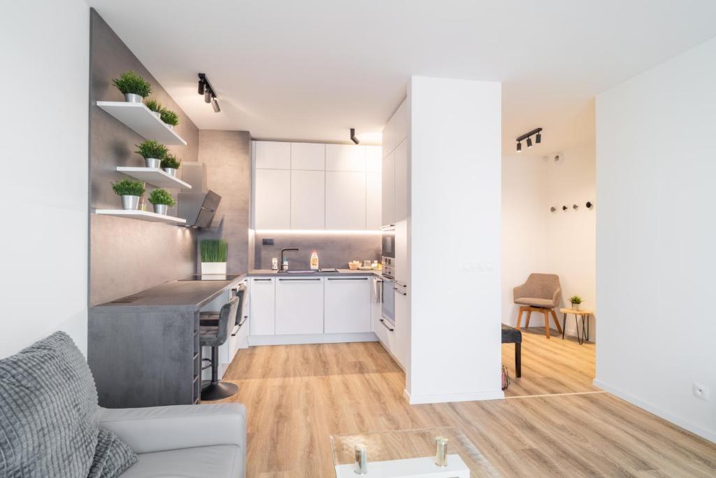 NEW Luxury 2 bedroom apartment, fully airconditioned, near the airport, FREE Parking في براتيسلافا: مطبخ وغرفة معيشة مع دواليب بيضاء