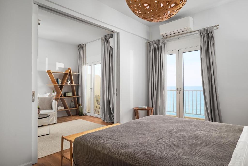a bedroom with a bed and a large window at Crete - Heraklion Sea View Apartment 1 in Heraklio Town