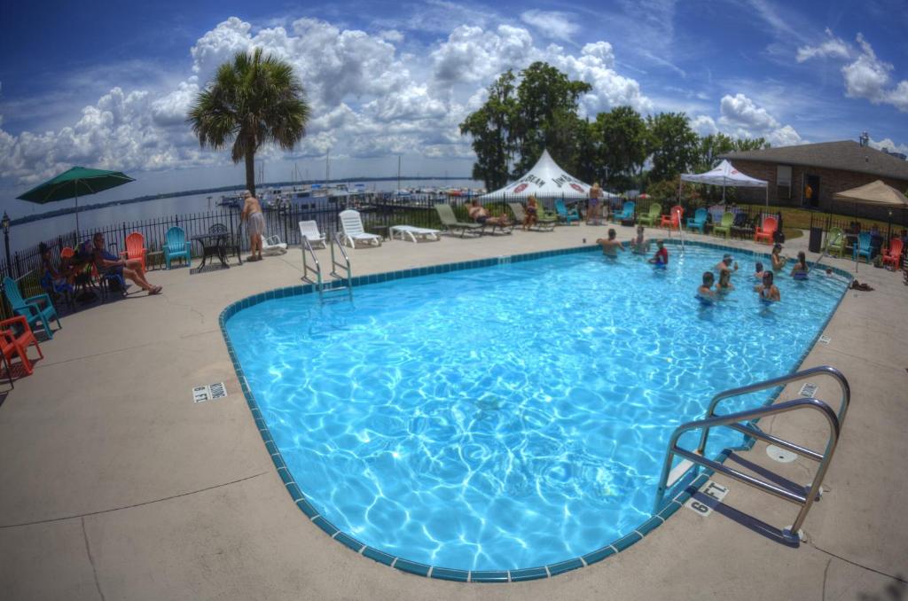 a large swimming pool with people sitting around it at Crystal Cove Riverfront Resort in Palatka