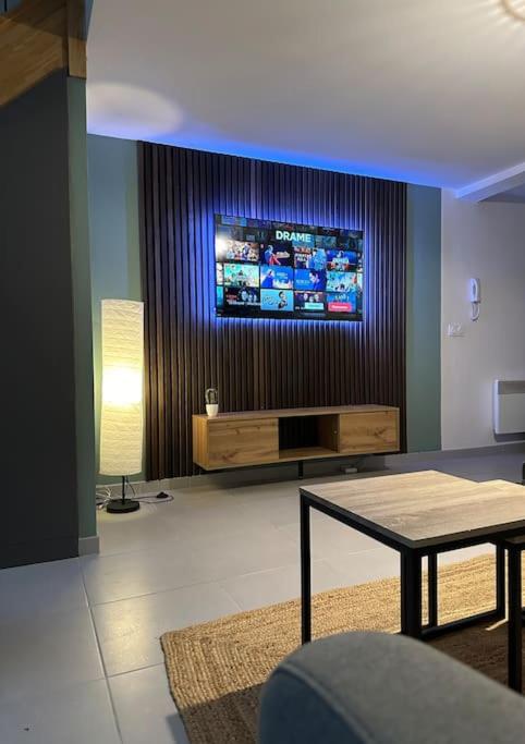 un salon avec une télévision et une table dans l'établissement Le 58 - Loft Robespierre, à Reims