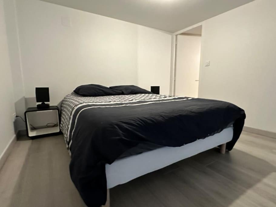 a bedroom with a bed with a black comforter at Le 58 - Loft Robespierre in Reims