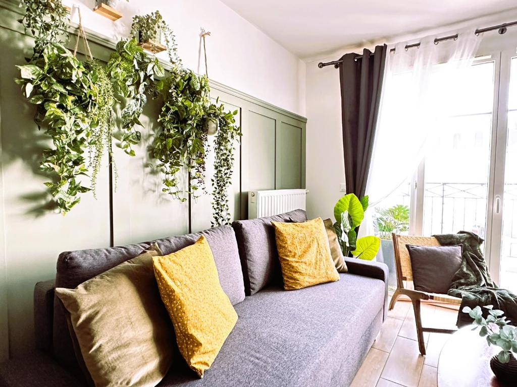 uma sala de estar com um sofá e muitas plantas em *New* Livy 6 pax Appart Disney em Serris