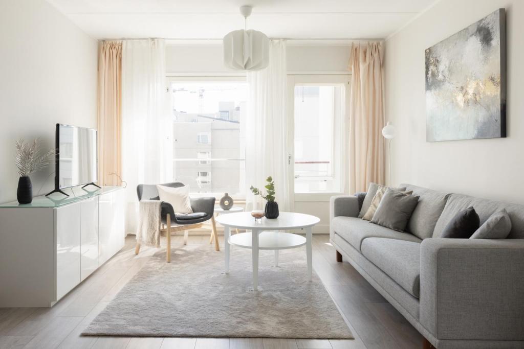 a living room with a couch and a table at Stunning design apartment with sauna & free parking in Helsinki