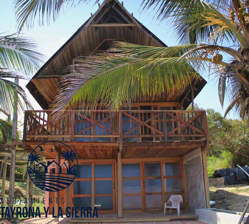 a house on the beach with a palm tree at Cabaña Rincón de los Cocos in Santa Marta