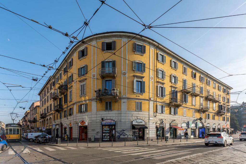 ミラノにあるMilano Apartments Navigliの通路角の黄色い建物