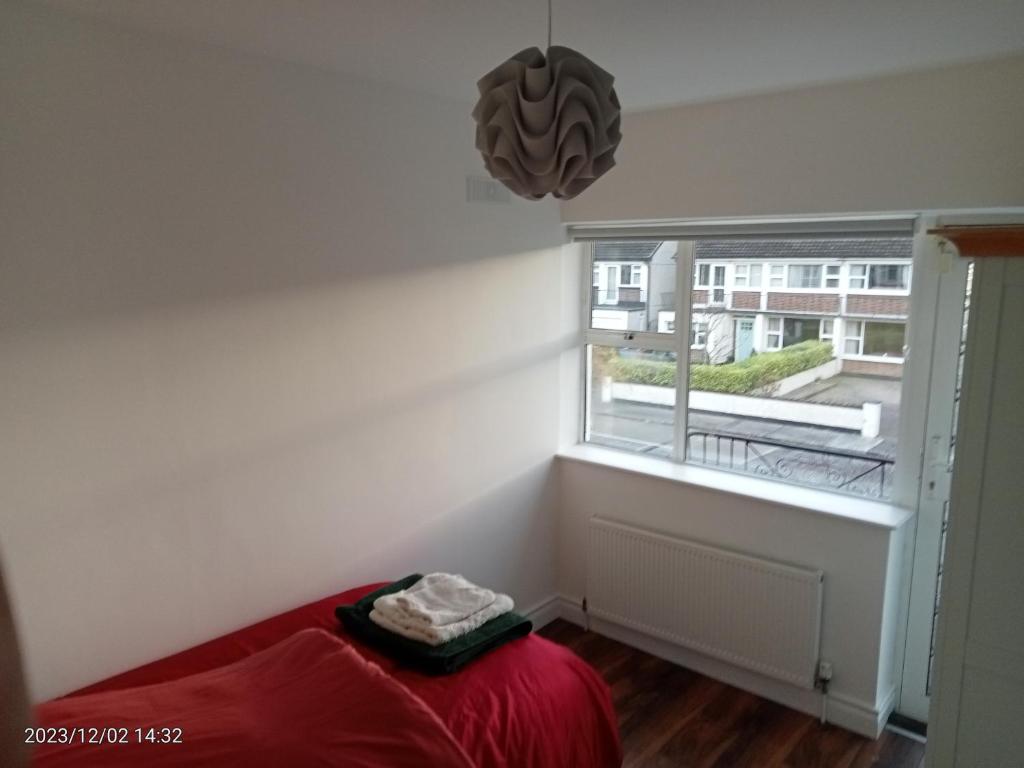 a room with a red bed and a window at Home away from home in Dublin