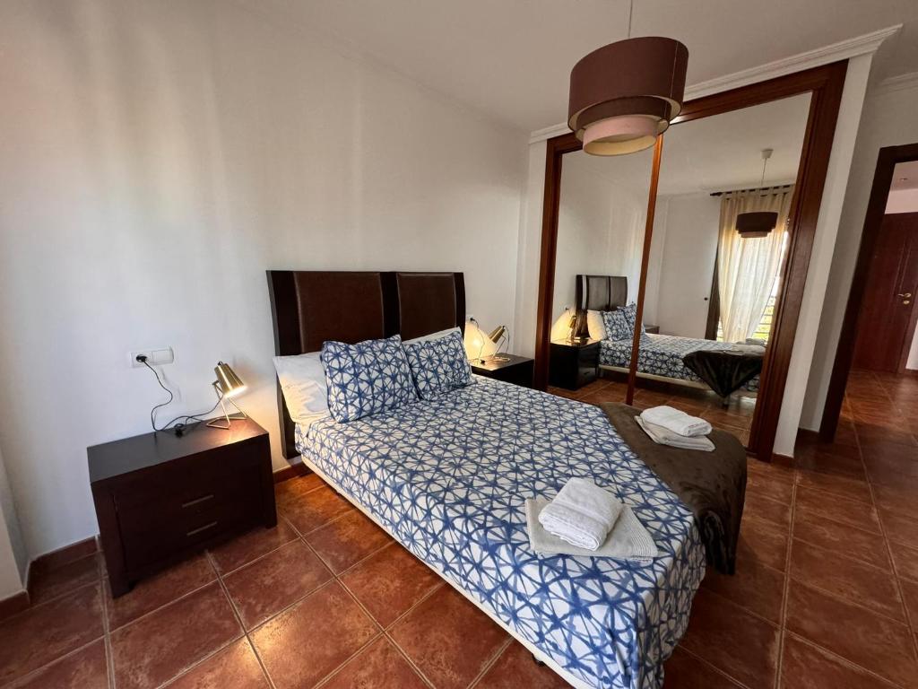 un dormitorio con una cama y un espejo en Alquilaencanarias Sotavento Paradise, en Granadilla de Abona