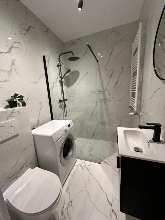 La salle de bains blanche est pourvue de toilettes et d'un lavabo. dans l'établissement D&M Apart Butikowa Kamienica 9, à Białystok