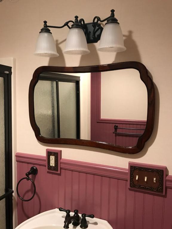 a bathroom with a mirror and a sink at Carriage Stop Bed & Breakfast in Palmyra