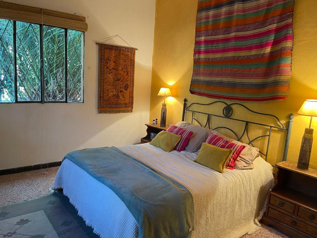 een slaapkamer met een bed met 2 kussens erop bij El Jardín Secreto Se pide seña para reservar in Piriápolis