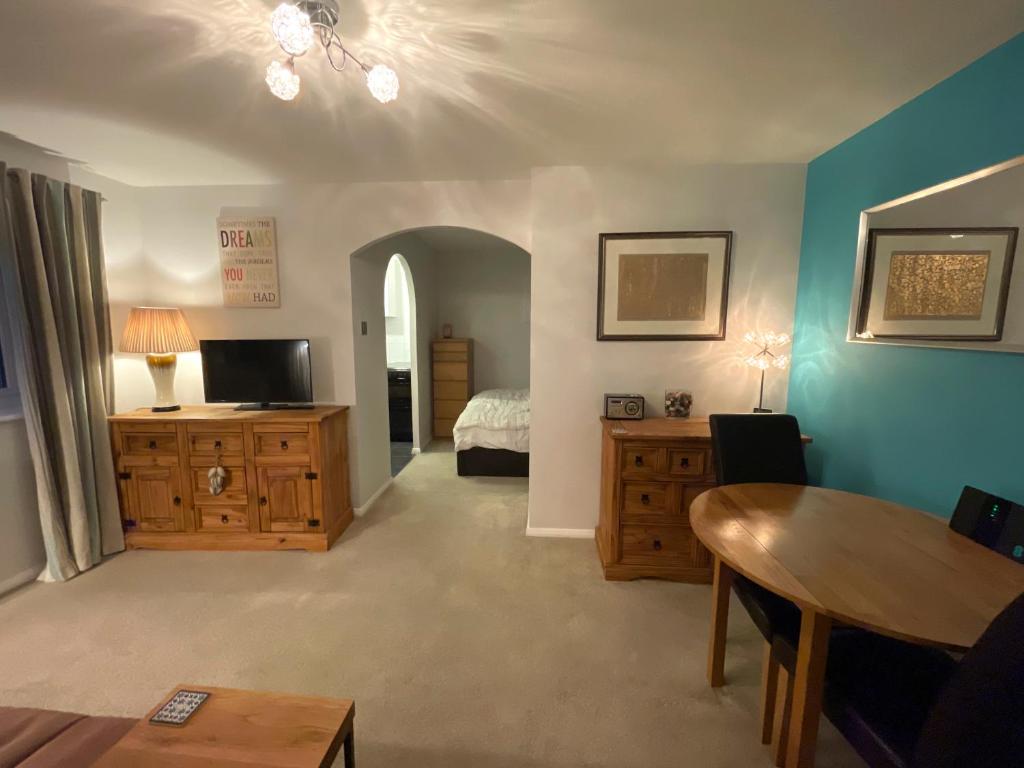 Habitación con 1 dormitorio con 1 cama y 1 mesa. en Beautiful Peaceful Studio Flat en Waltham Abbey