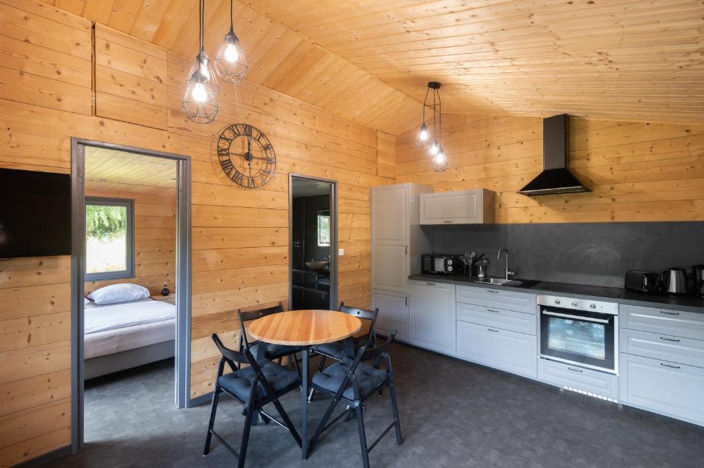 a kitchen with a table and chairs in a room at Chalet du Faubourg & Jacuzzi, proximité Gerardmer & La Bresse in Rochesson