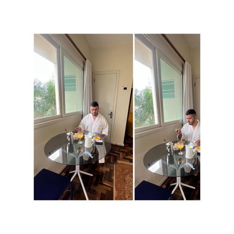 a man sitting at a table in a room at Hotel Ibiá in Montenegro