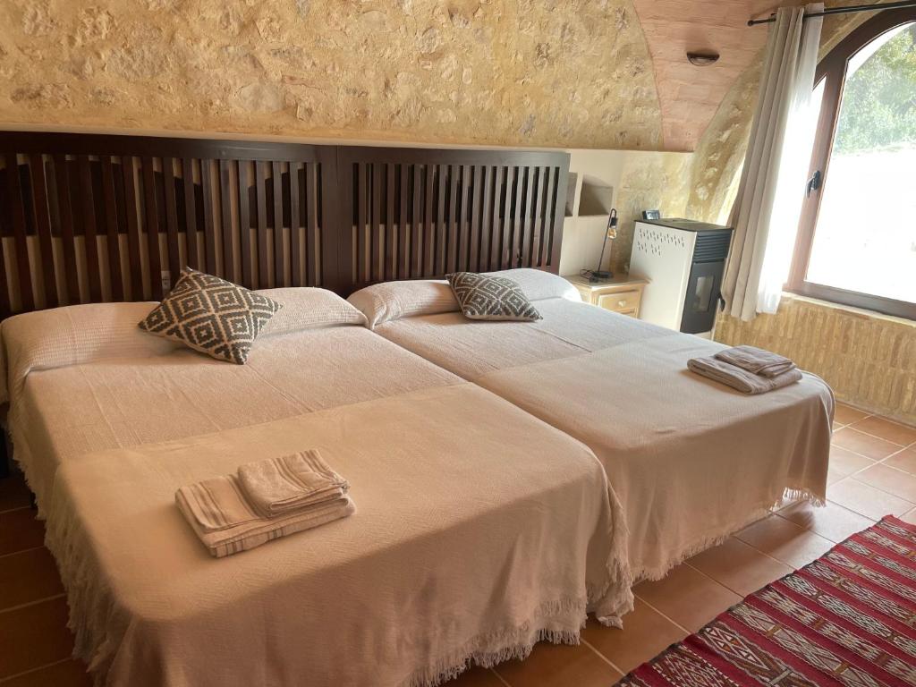 a bedroom with a large bed with two pillows on it at Viña Zarzarrosa Osuna in Osuna