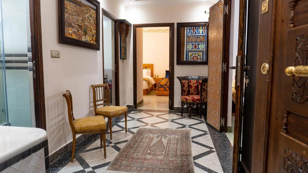 a hallway with two chairs and a rug on the floor at Dar Bouzoubaa in Fez