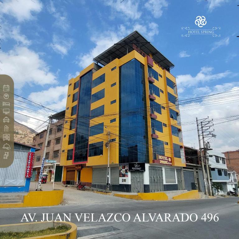 un edificio amarillo y negro en una calle de la ciudad en Hotel Spring, en Huánuco