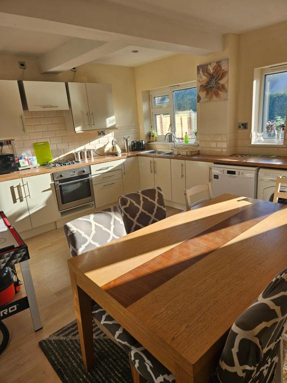 uma cozinha com uma mesa de madeira num quarto em 5 BEDROOM HOUSE- 7 BEDS - SEPARATE LIVING ROOM- WIFI -GARDEN- Parking em Birmingham