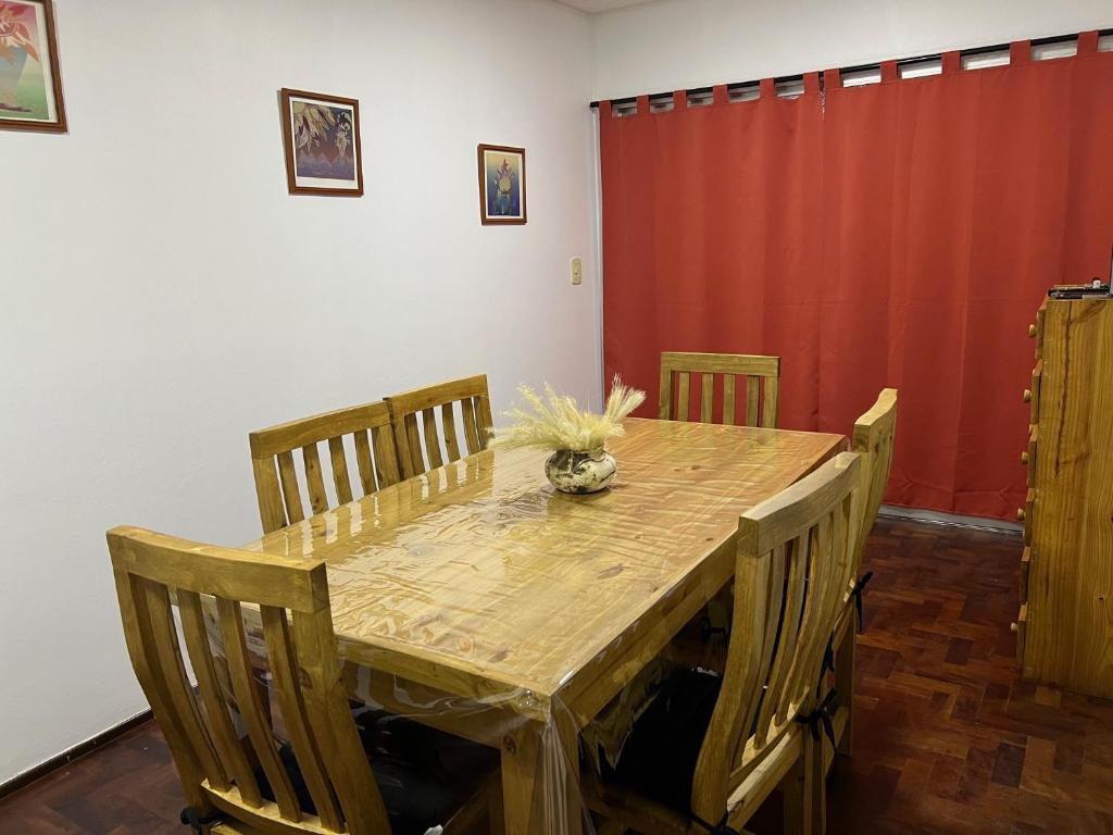 a dining room table with chairs and a wooden table and a red curtain at Mendoza Center in Mendoza