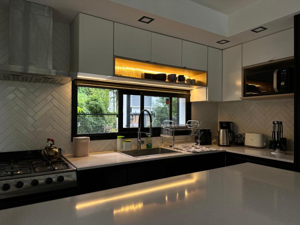 eine Küche mit einer Spüle, einem Herd und einem Fenster in der Unterkunft La Cayetana in Mar del Plata