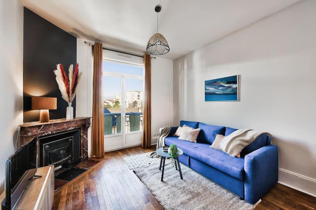 un soggiorno con divano blu e camino di Grand T2 entier-5p-2 balcons - Appartement central a Saint-Fons