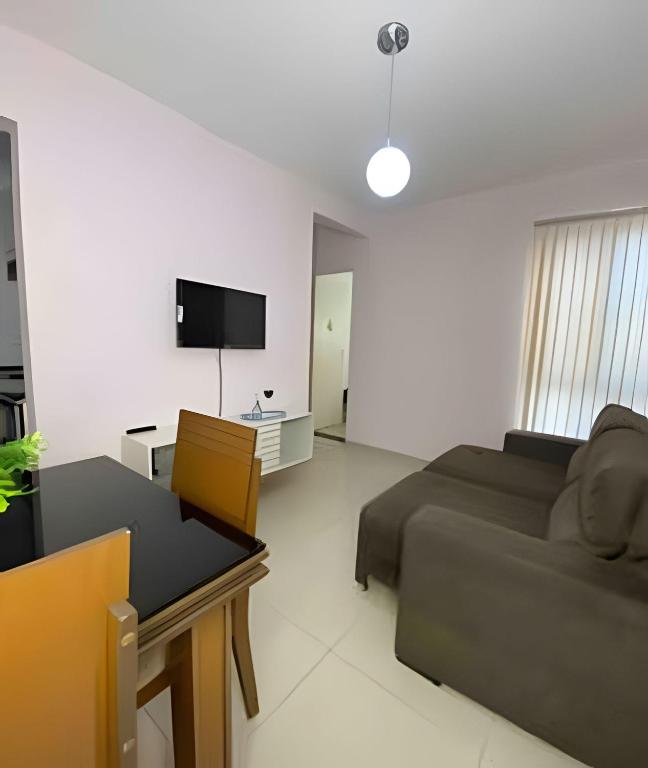 een woonkamer met een bank en een televisie bij Ap exclusivo 2/4 completo in Feira de Santana