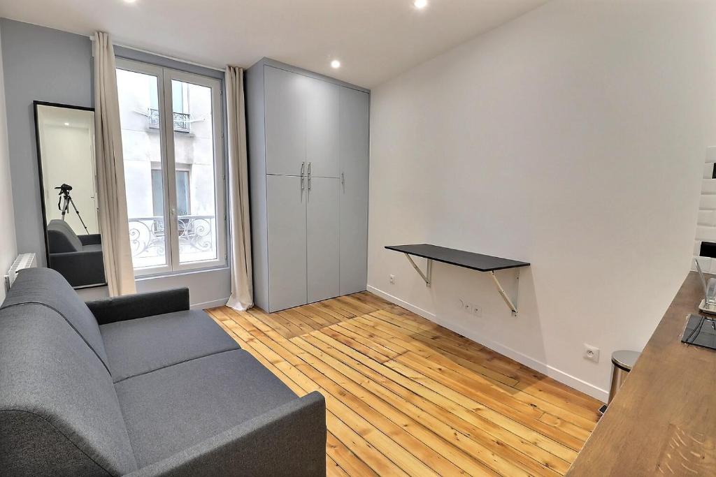 a living room with a couch and a table at Appartement 2 personnes Paris in Paris