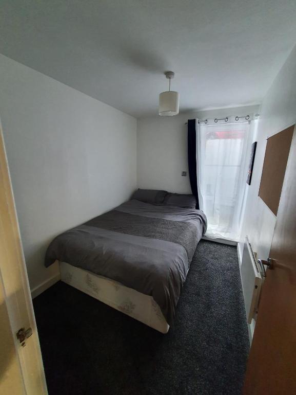 ein kleines Bett in einem kleinen Zimmer mit Fenster in der Unterkunft Quiet 2 bedroom flat in Darlington with free parking, wi-fi and more in Darlington