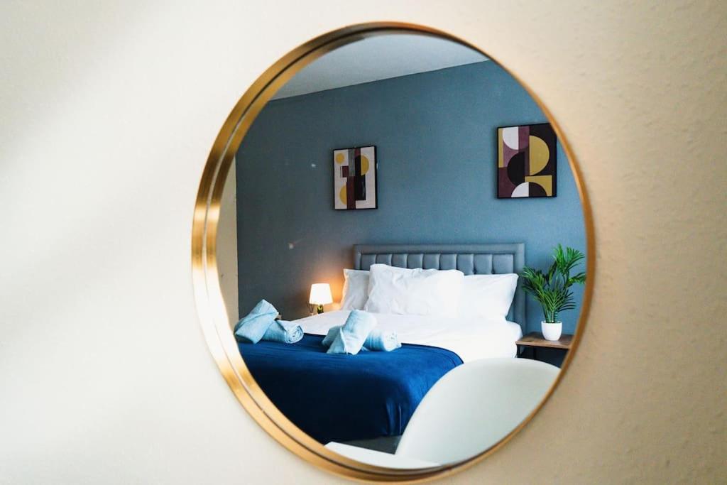 a mirror in a bedroom with a bed and a chair at Cosy 2BR Flat - Beach Nearby in Kent