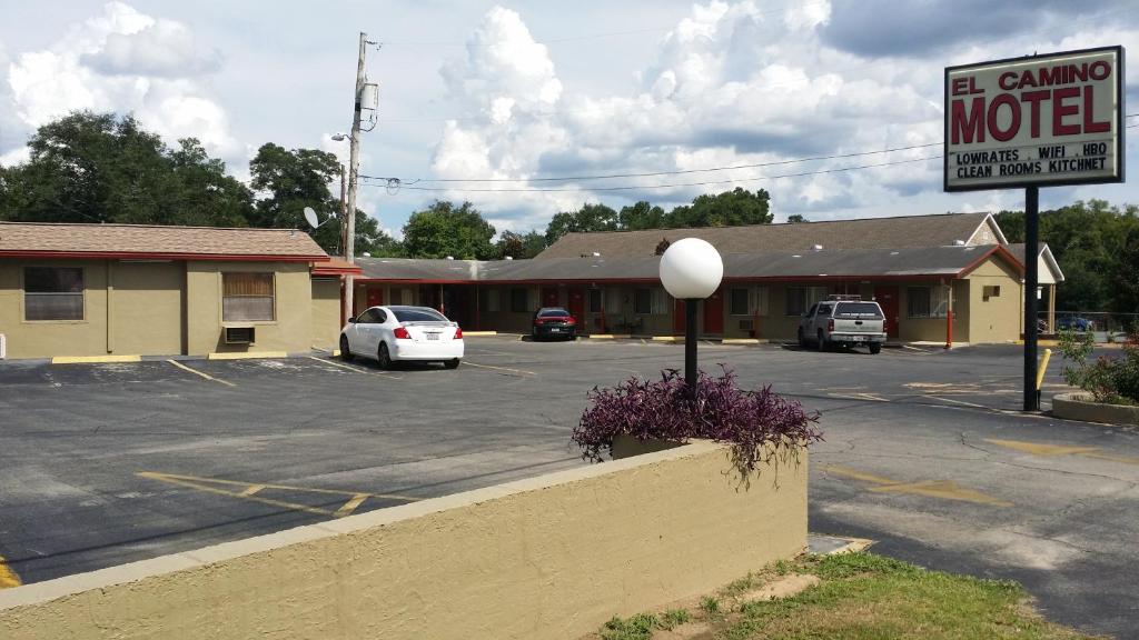 a building with a motel sign and a parking lot at El Camino Motel in Tallahassee