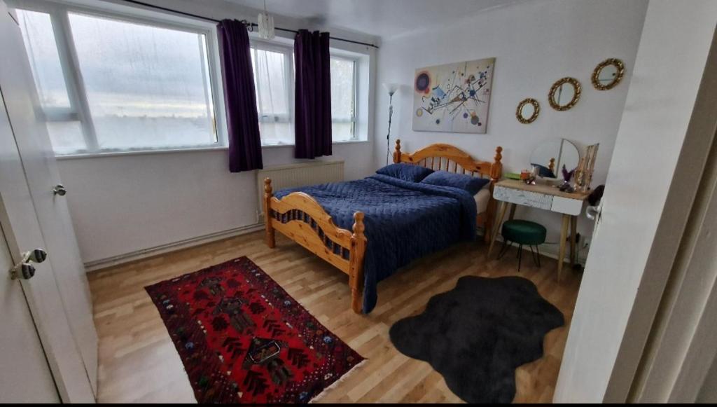 een slaapkamer met een bed, een bureau en een raam bij Spacious flat near central in Londen