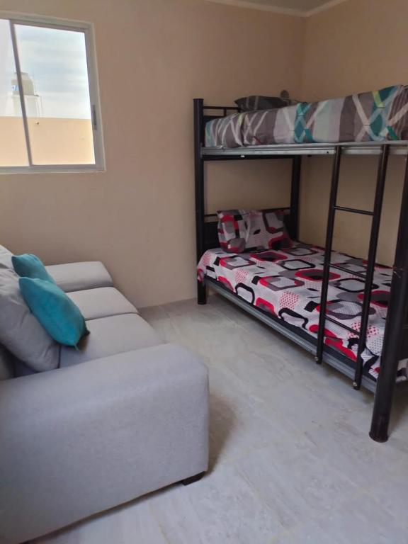 a room with two bunk beds and a couch at casa jardines san francisco in Valladolid