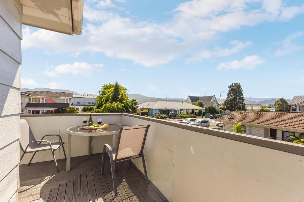 a balcony with a table and chairs and a view of a street at Central CBD in Motueka